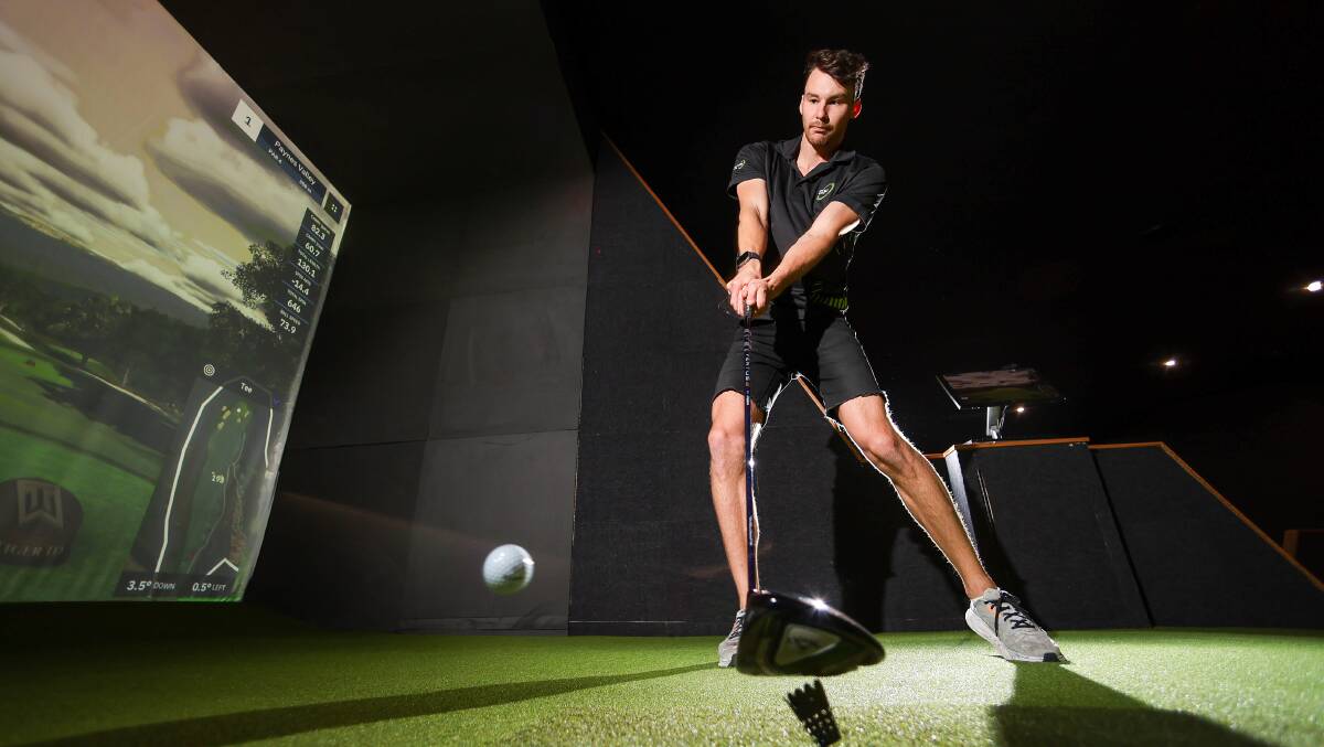 Mitchell Bloomfield demonstrates the indoor golf simulator at Smash Factor Indoor Golf & Bar, Wollongong. Picture by Adam McLean