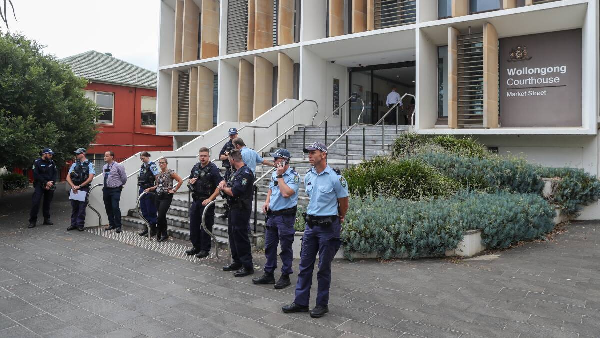 Police officers guarding the entry to Wollongong courthouse after a group of 30 were escorted outside. Picture by ACM
