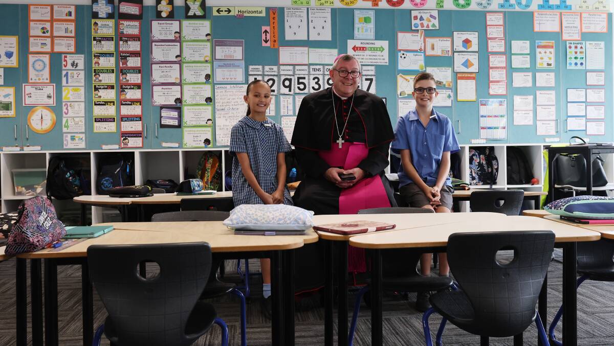 Bishop of Wollongong Brian Mascord with school captains Ella Primmer and Grady Farrugia in a classroom at St John's Catholic Parish Primary School. Picture by Sylvia Liber