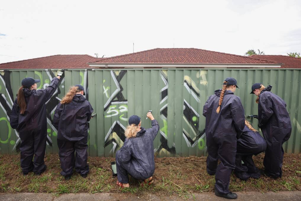 Students from Albion Park High School painting a section of the laneway. Picture by Adam McLean