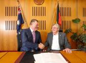 Hall & Prior CEO Graeme Prior and Kiama Mayor Neil Reilly shake hands after signing the sale contract for the Blue Haven Bonaira aged care facility Picture by Adam McLean