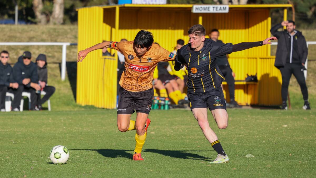 Coniston Takayuki Kayano (left) battles to keep possession away from a Helensburgh opponent during their Premier League clash at JJ Kelly Park on Saturday. Pictures by Wesley Lonergan