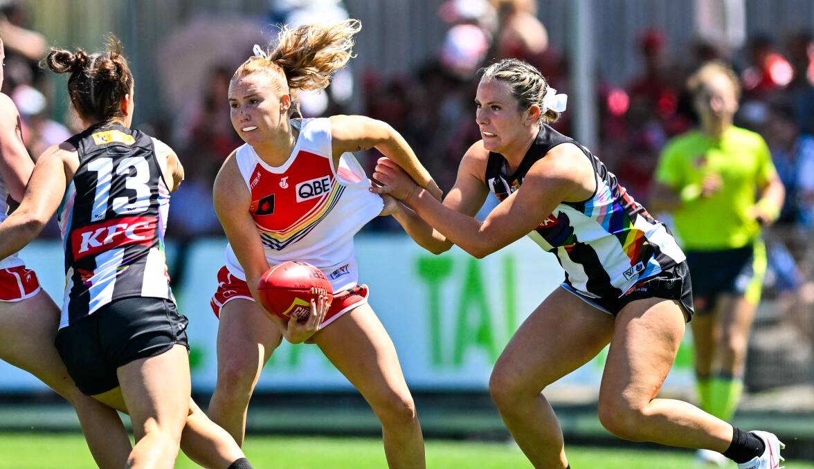 Woonona's Ruby Sargent-Wilson gets a handball away while under pressure from a Collingwood opponent. Picture by Keith McInnes Photography