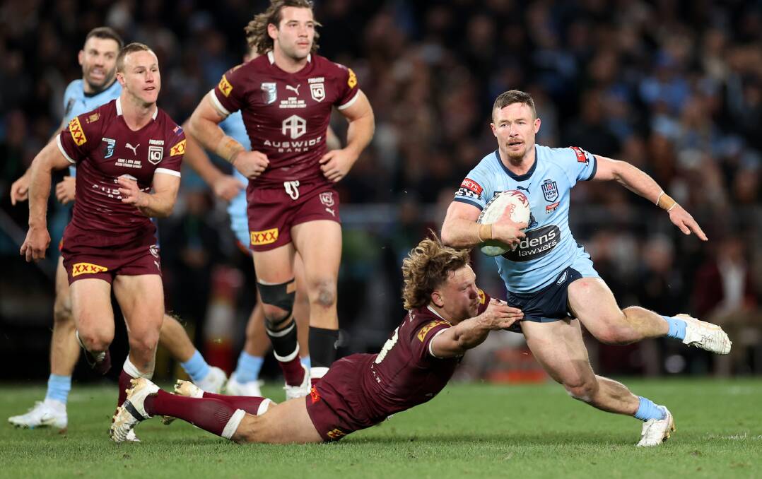 Blues hooker Damien Cook evades the tackle of Reuben Cotter during game one of the 2022 State of Origin series. Picture by Cameron Spencer/Getty Images
