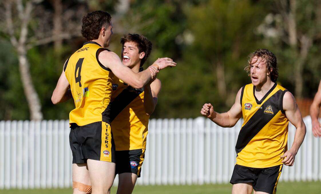 Ciaran Flynn (left) and his Tigers teammates celebrate after kicking a goal during a match against Figtree last August. Picture by Anna Warr