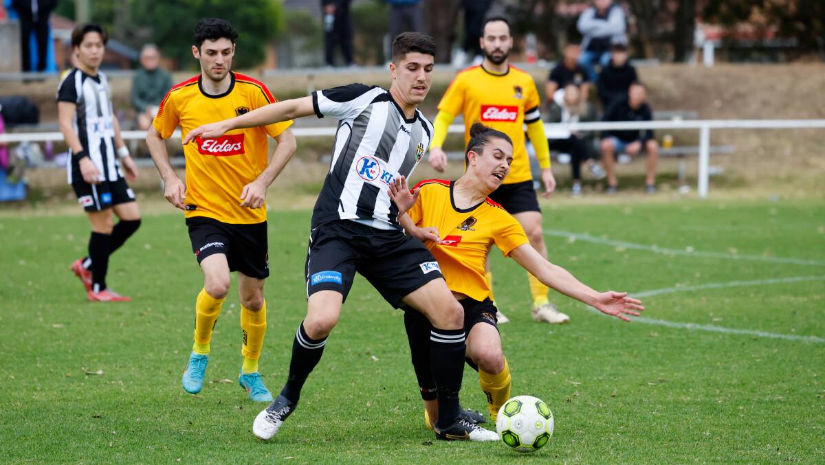 Port Kembla's Sebastian Tomasiello (left) battles with a Coniston opponent for possession during a Premier League game last year. Picture by Anna Warr