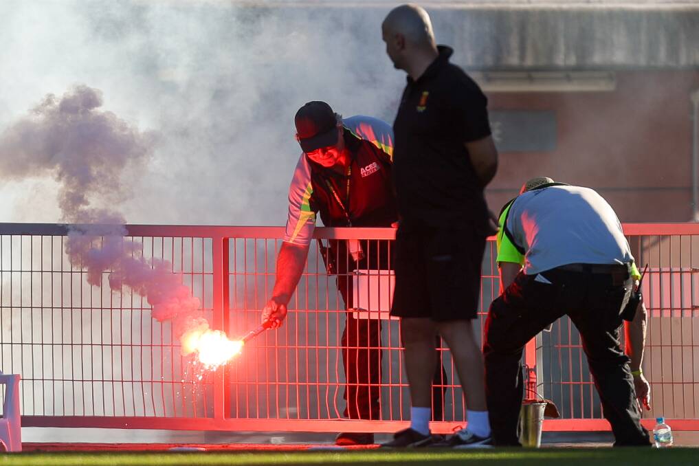 A security guard picks up one of the flares set off during the 2023 Illawarra Premier League grand final at WIN Stadium on September 17. Picture by Adam McLean