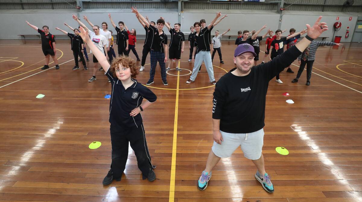 Southern Stars participant Harvey Rintoul and choreographer Craig Nhobbs with members of the Southern Stars Boys Vocal Ensemble during rehearsals at Berkeley Sports Stadium. Picture by Robert Peet