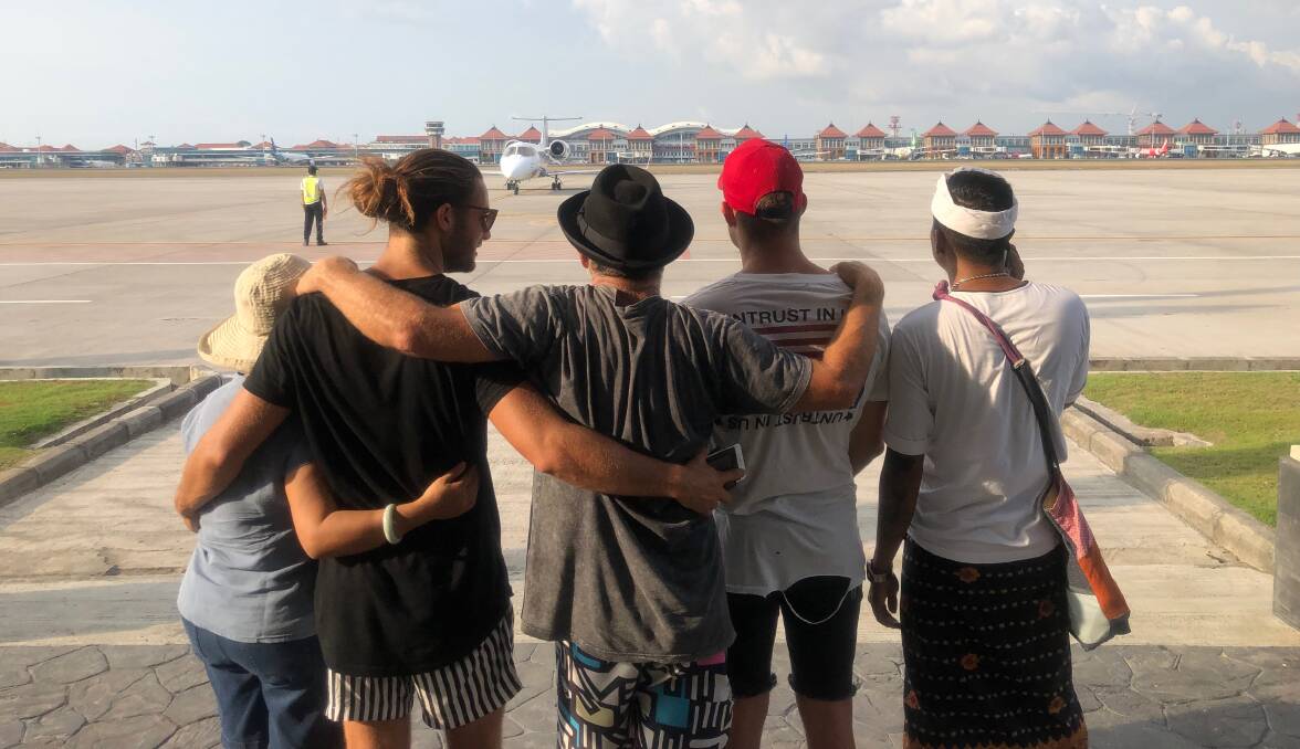 We did it: From left, nurse Cristina De Leon, Nelson Rankin, David Rankin,Campbell Rankin and Toekik Slemat watch from the tarmac in Bali as the Medical Rescue flight prepares to take Lawson Rankin home.