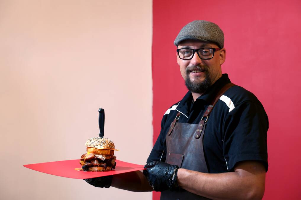 William Plotz and his dad Johan have opened Woonona's new eater for meat-lovers, Big Lapa (William is pictured with their brekkie burger). Picture by Sylvia Liber.