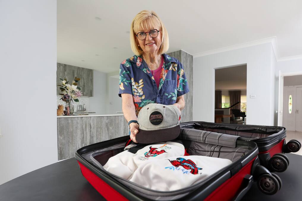 Kris Burgh packs her husband Phil's Hawks kit ahead of their trip to Tasmania on Wednesday. Picture by Adam McLean