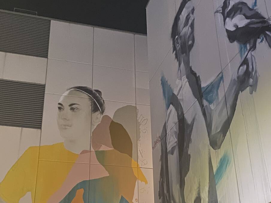 A portrait of Matildas star Caitlin Foord nears completion at the Market St entrance to Wollongong Central on Tuesday night. Picture: Janine Graham