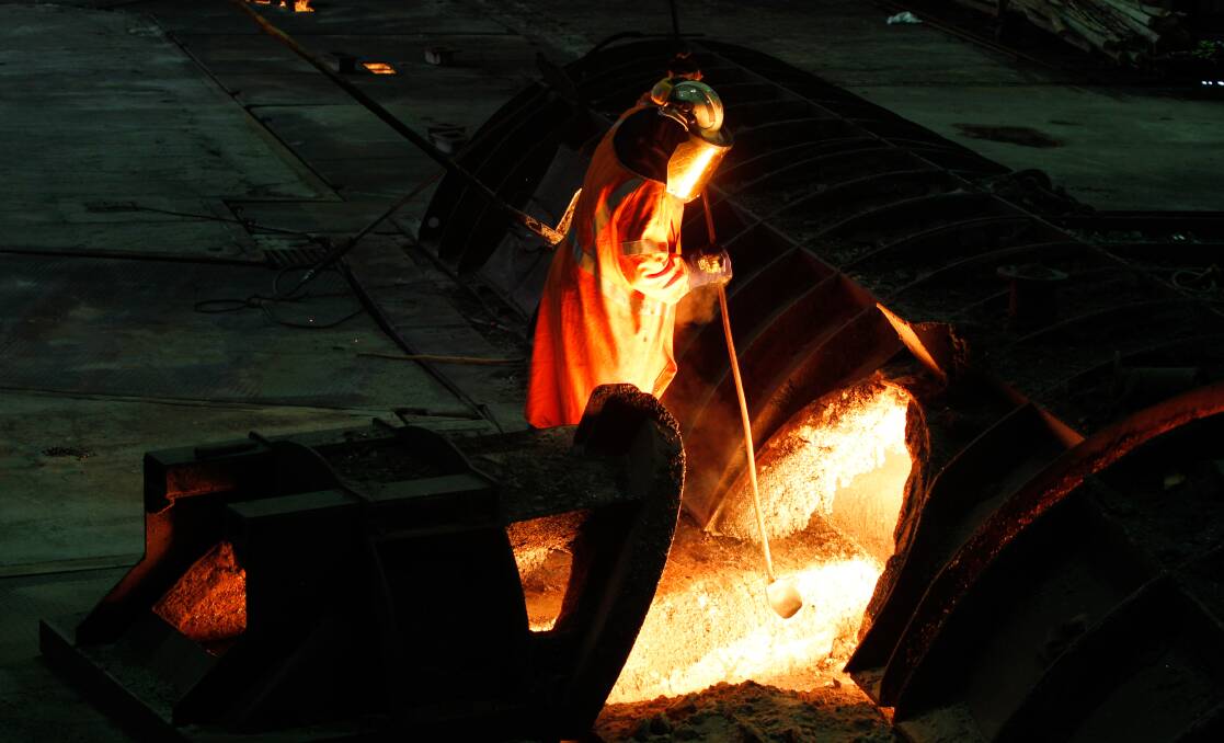 A worker tends to molten iron inside a Port Kembla blast furnace, the heart of the steelmaking operation for BlueScope.