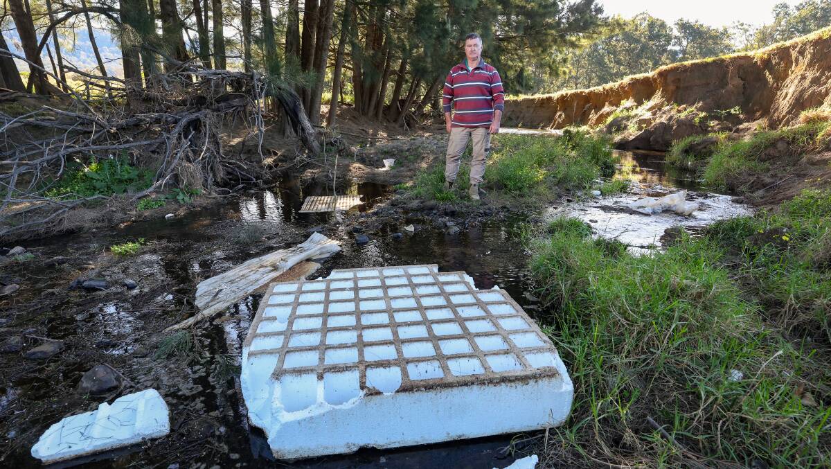 Chris Barham with a waffle pod that has blown into Forest Creek from a nearby building site at Wongawilli. Picture by Adam McLean.