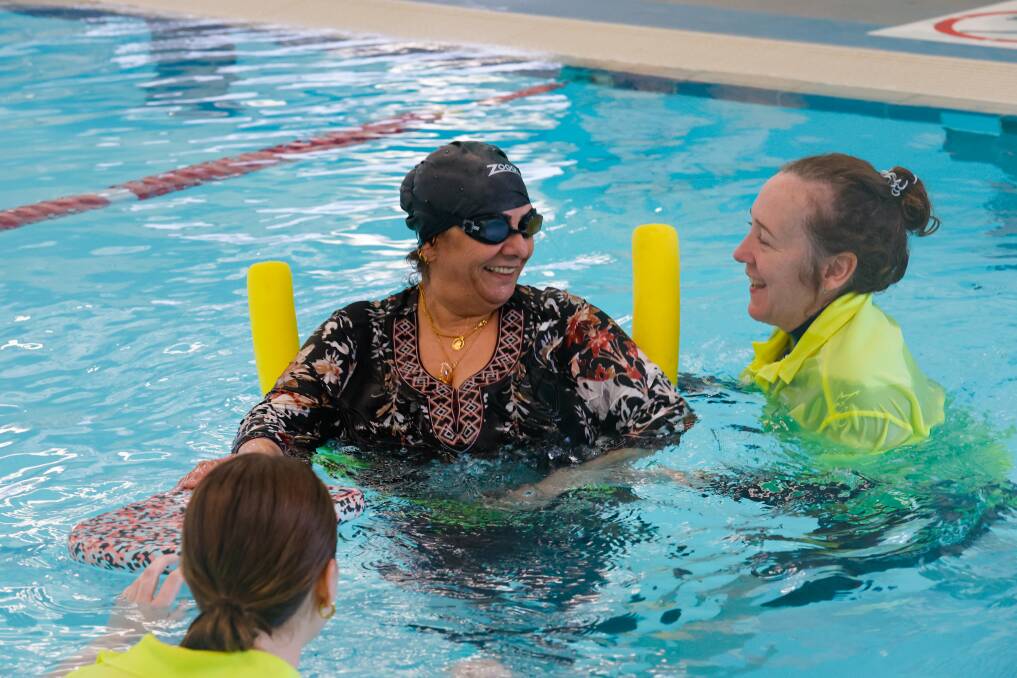 Swim program participant Gazeyah Al Arb in the pool with instructors. Picture by Anna Warr