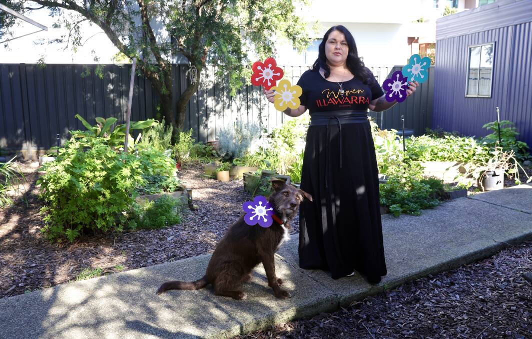 Women Illawarra's Dee Blackmore and dog Mungo with some of the flowers that will be used in an installation to honour the women and children lost to gendered violence. Picture by Sylvia Liber