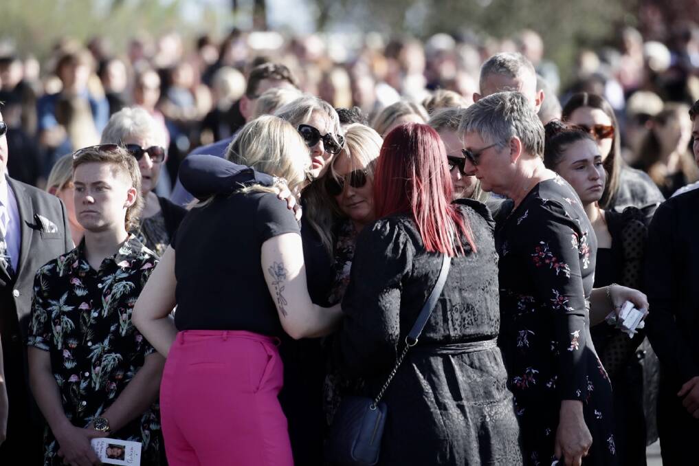 Lily's mother and sister are comforted outside the church. Picture by Adam McLean.