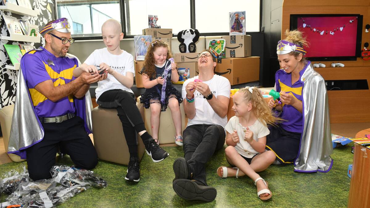 Kids Laycee Davidson (right); Jenson Lambeth and Sophey Lill with Starlight Foundation superheroes and singer Johnny Ruffo. 