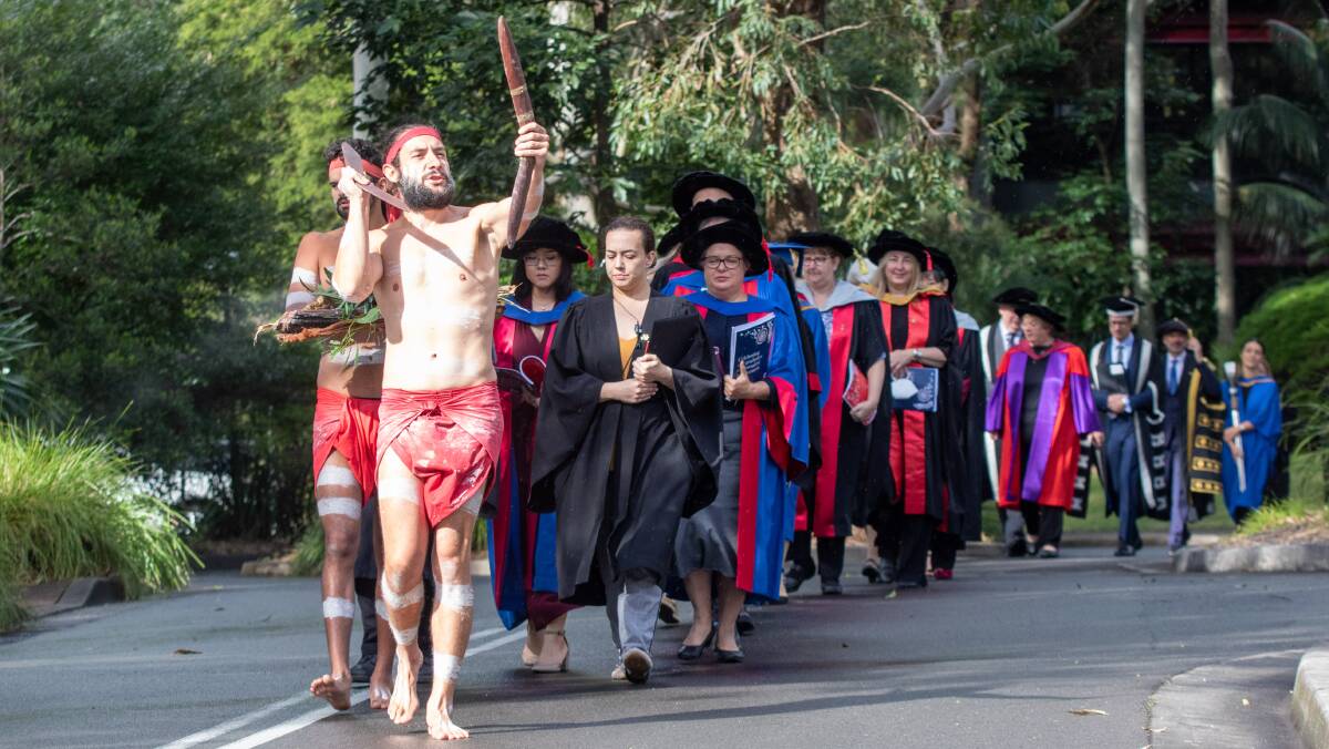 The academic procession being led by a traditional smoking ceremony at a recent University of Wollongong graduation ceremony. Picture supplied.