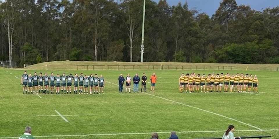 Shamrocks and Shoalhaven players observe a minute's silence for the late Garth Doyle.