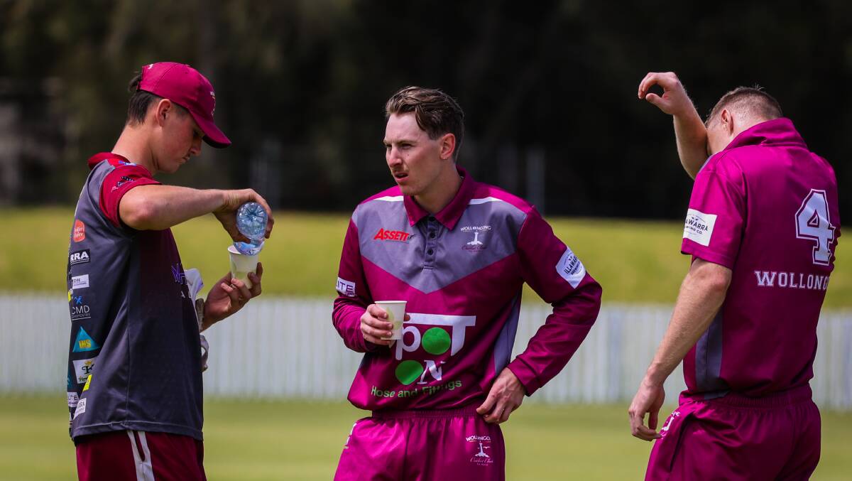 Cooper Maddinson (middle) enjoys a drinks break with his Wollongong skipper Toby Dodds (No 4). Picture by Wesley Lonergan
