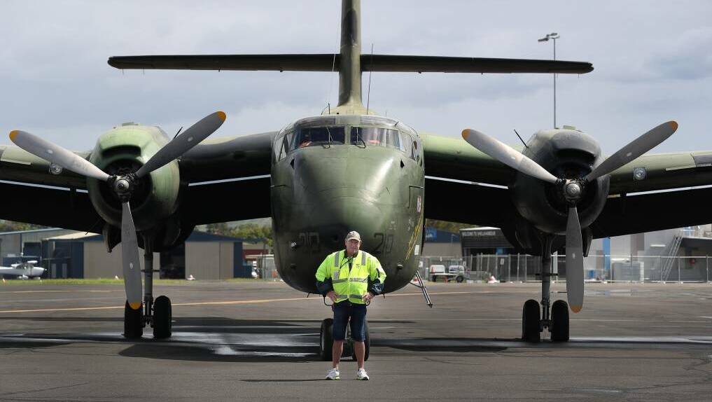 A HARS volunteer stands in front of one of the mighty planes on display. 