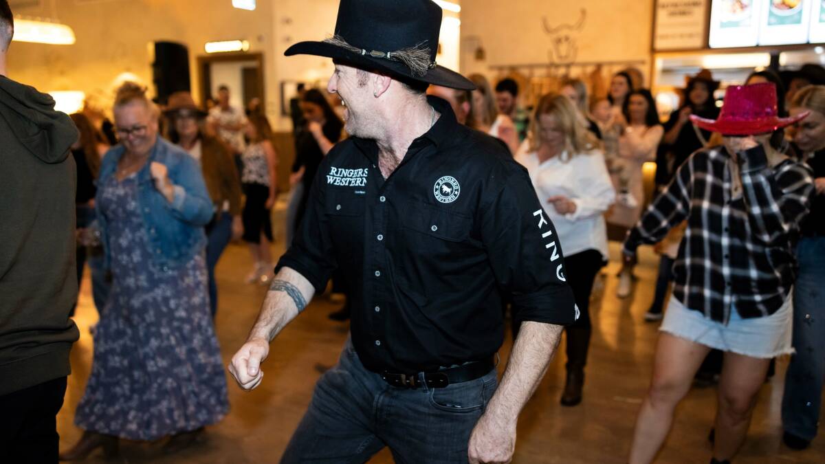 A man in a cowboy hat leads the line dancing at the Plough and Ale.