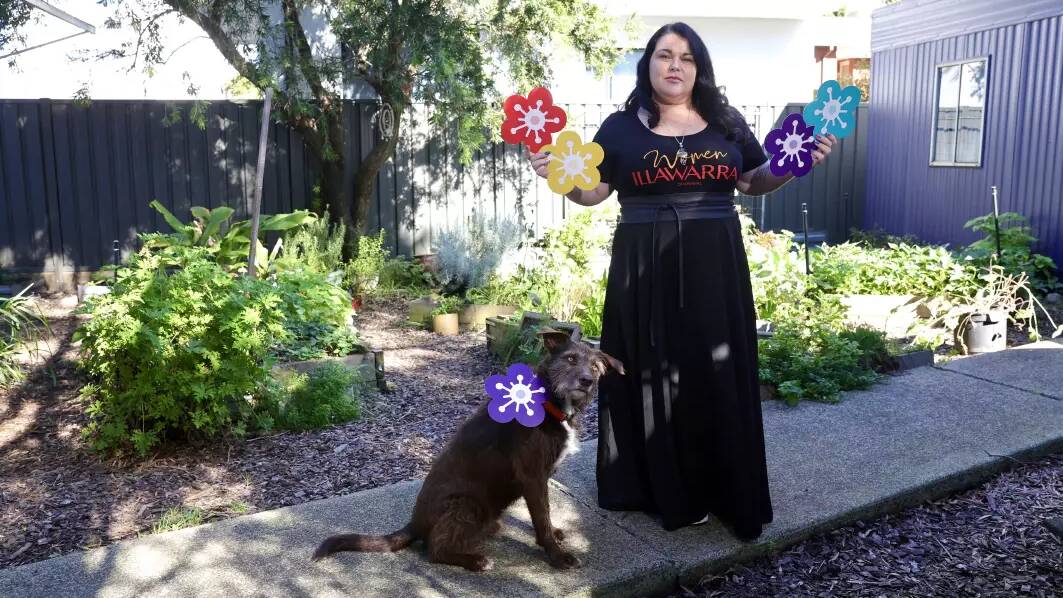 Women Illawarra's Dee Blackmore and dog Mungo with some of the flowers that will be used in an installation to honour the women and children lost to gendered violence.