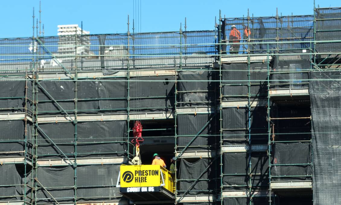 Construction staff working at heights on a building site in Wollongong. Picture by Sylvia Liber