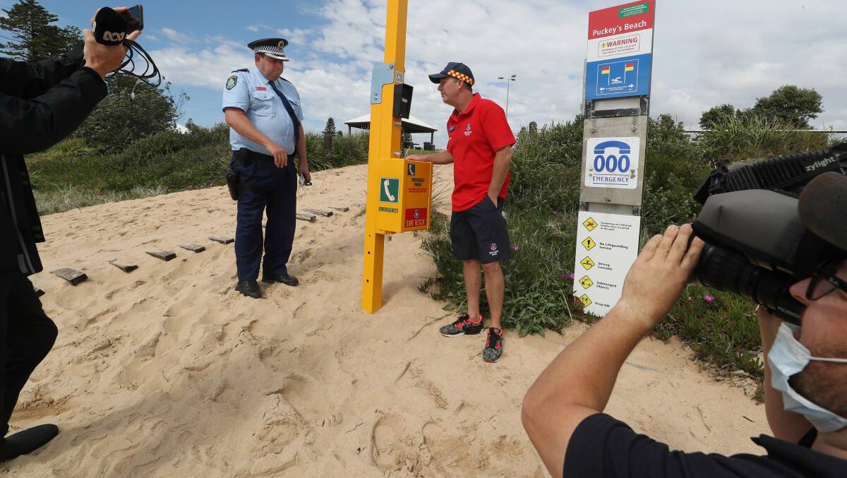Chief Inspector Darren Brown and Surf Life Saving Illawarra duty officer Anthony Turner when an emergency phone was installed at Puckeys Beach in October 2021. Picture by Robert Peet