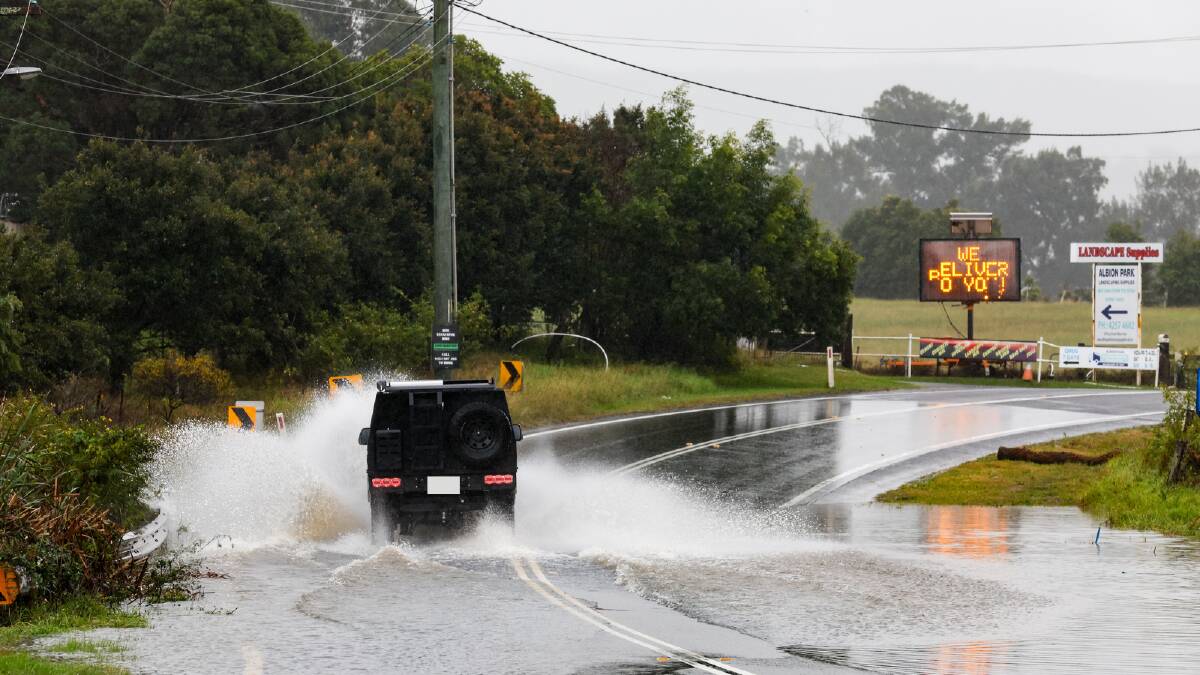 A car driving through floodwaters at Albion Park on Friday, June 7, 2024. Picture by Anna Warr