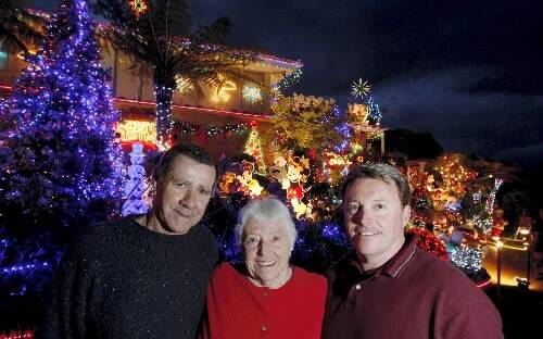 Craig Hughes (right), with his mum Joyce Hughes and helper and friend Rick Dawes,  in front of the Cuthbert Dr home display in Mt Warrigal.