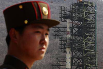 A soldier stands guard in front of the Unha-3 (Milky Way 3) rocket sitting on a launch pad at the West Sea Satellite Launch Site in North Korea. Photo: REUTERS/BOBBY YIP