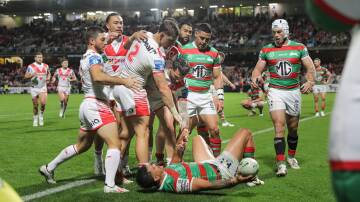 Dragon Zac Lomax offers Souths fullback Latrell Mitchell a hand up after scoring at Kogarah on Saturday. Picture by John Veage