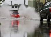 A file image of cars drive across a flooded road in Wollongong. Picture by Adam McLean